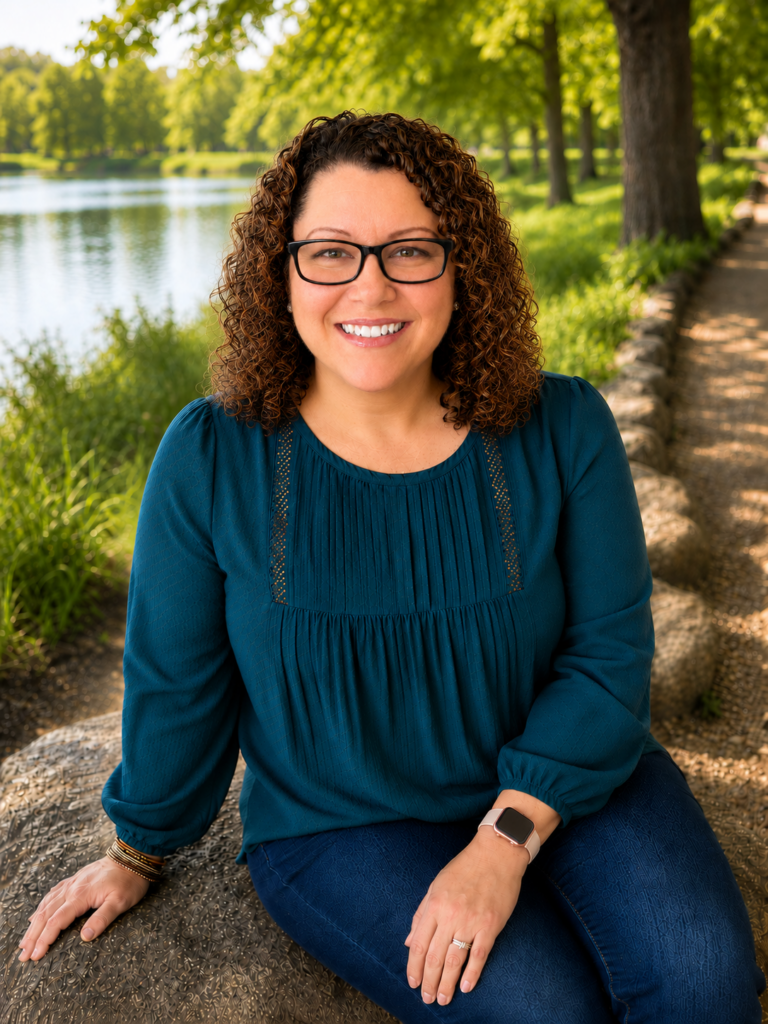 Portrait of Samantha Schalk, LMSW, smiling outdoors in a park beside a lake.